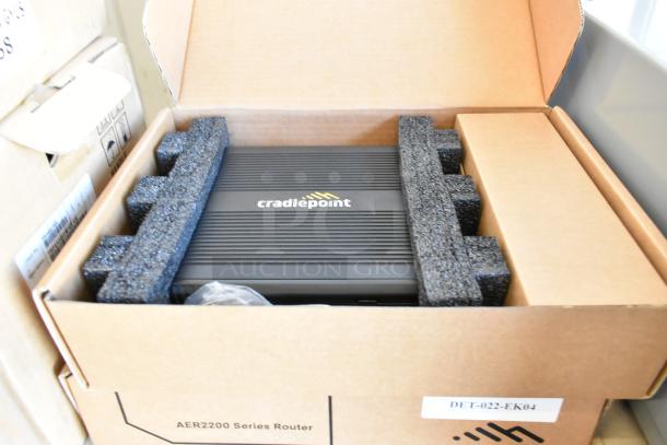 Brand new Cradlepoint AER2200 router in box with protective foam, part of a bundle with Star TSP100III receipt printer.