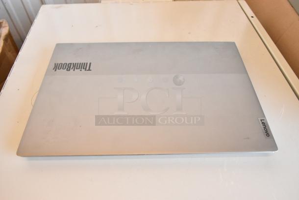 11 Lenovo ThinkPad, Dell, HP laptops; image shows a closed Lenovo ThinkBook with visible branding, light wear.