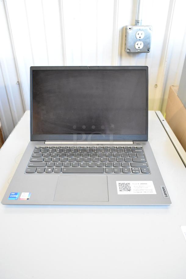 Lenovo laptop with Intel Core i5, 11 included in auction. Features a sticker with asset details and Lenovo branding.