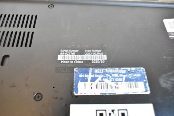 Close-up of a laptop's underside showing serial number R9-0ZZT6, type number 20J3-002AUS, and manufacturing details.