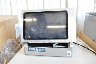 Date Code Genie DCGX2 Label Printer, silver casing, touchscreen, moderate wear, branding visible. Ideal for label printing.