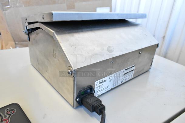 Date Code Genie DCGX2 Label Printer, metal casing, used condition, power cord, model and warning labels visible.