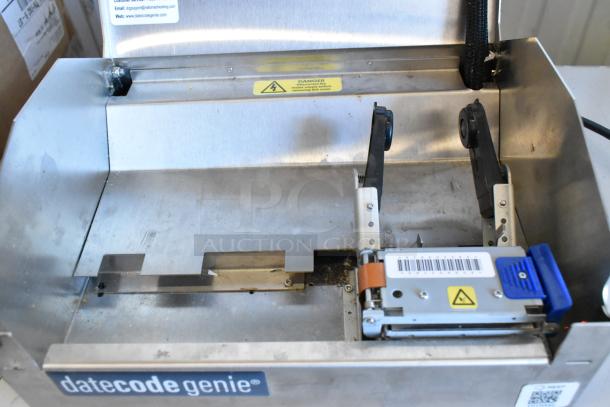 Date Code Genie DCGX2 Label Printer, stainless steel casing, visible barcode, caution label, used condition.