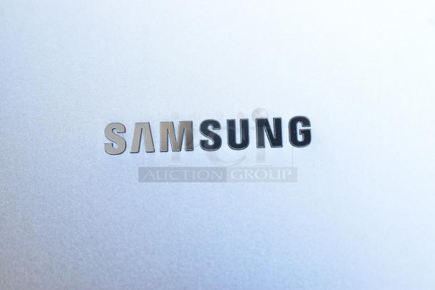 Samsung logo on a metallic surface, possibly part of a Samsung device from the auction lot including various items.