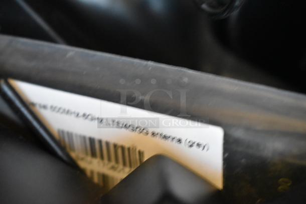 A blurry close-up of a label with partial text, possibly indicating a 698MHz-4.2GHz LTE/WiFi antenna. Part of a lot including an AKG SM-T720 tablet and Mako routers.