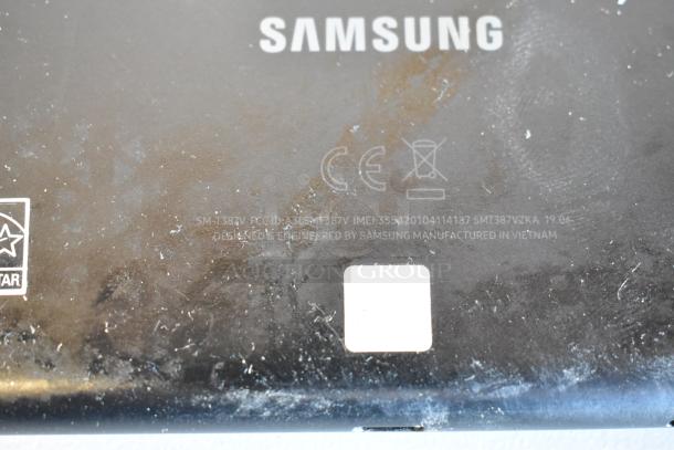 Rear view of a Samsung tablet with visible brand logo and model number SM-T387V. Condition shows wear with scratches and marks.