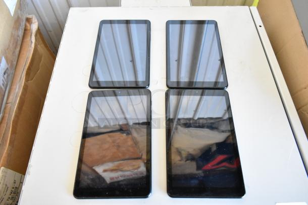 Four Samsung tablets displayed on a table, various models, condition appears used. Auction offers 4 tablets per bid.