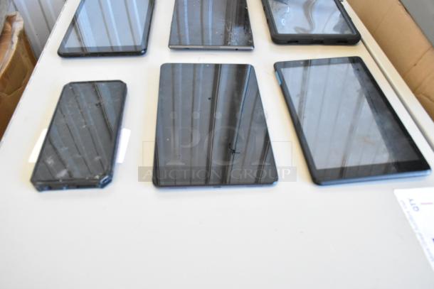 Six assorted tablets, including Samsung, on a table. Condition varies, screens visible. Auction: six times your bid.