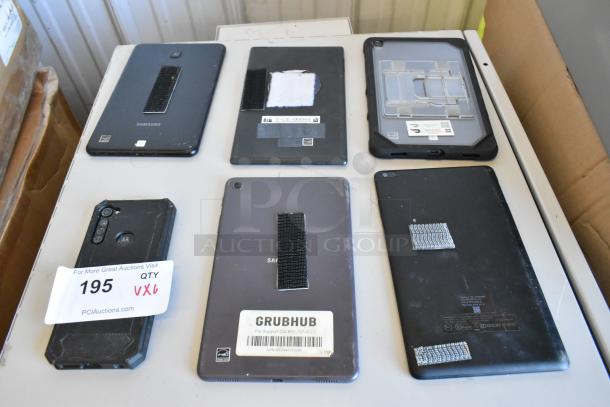 Six various tablets including Samsung, shown with visible wear and Velcro strips on the back. Some labels display model details and business tags.