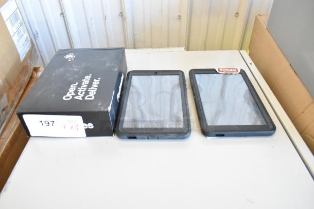 10 various tablets, including Samsung, on a table with packaging. Mixed condition, sold as-is. Box labeled "Open. Activate. Deliver."
