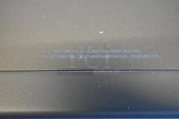 Gray tablet with label reading "SM-T290 FCC ID: ZCASMT290 Made in China. For information call 1-800-Samsung S/N: R9WN40LZZ9J".