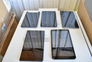 Five assorted tablets including Samsung, displayed on a table. Condition appears used, varying models shown. No visible tags.