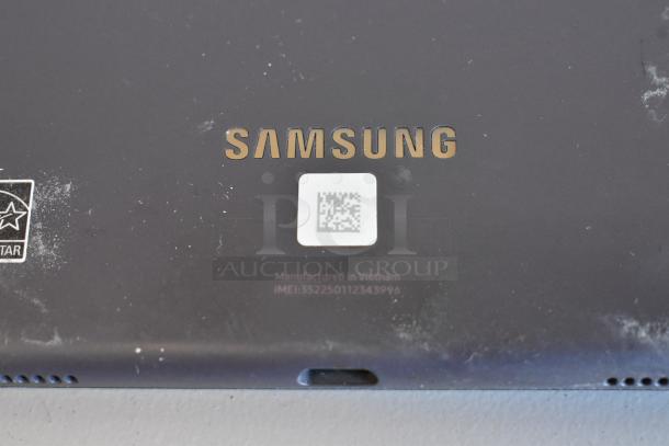 Samsung tablet close-up showing logo, QR code, and IMEI 352250112343996. Visible wear on surface.