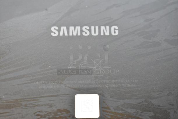 "Samsung logo and manufacturing details on black surface; indicates maker and model info for included table in auction set."