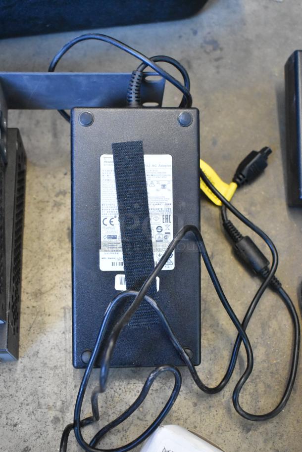 Auction lot featuring a Hewlett Packard power adapter with visible label, cables, and various electronic items.