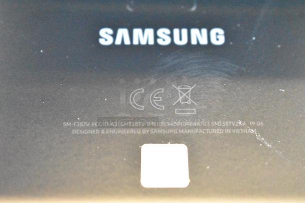 Samsung tablet back view, model SM-T387V, with visible CE and FCC markings. Designed in Vietnam.
