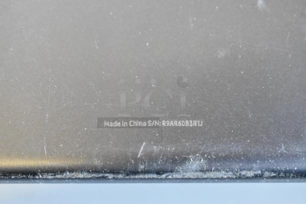Back of a tablet showing markings "Made in China" and serial number R9AR60B3R1J, surface shows wear.