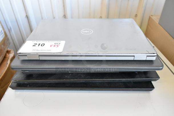 Stack of 5 laptops including Dell and HP, varying models, showing moderate wear. Auction tag says "210 QTY 5X".