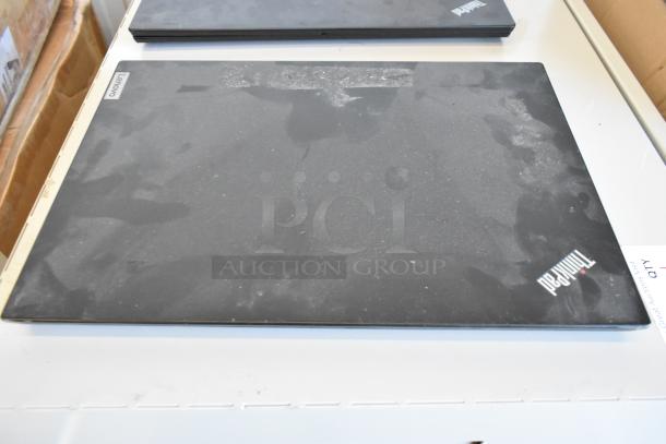 Five various laptops, including Dell and Lenovo models, on display. Laptops show signs of wear and dust.