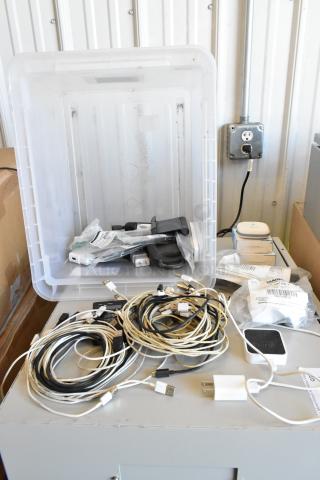 Various electronic items including a Govee WiFi Thermo Hygrometer, multiple cables, and connectors in a clear plastic bin.