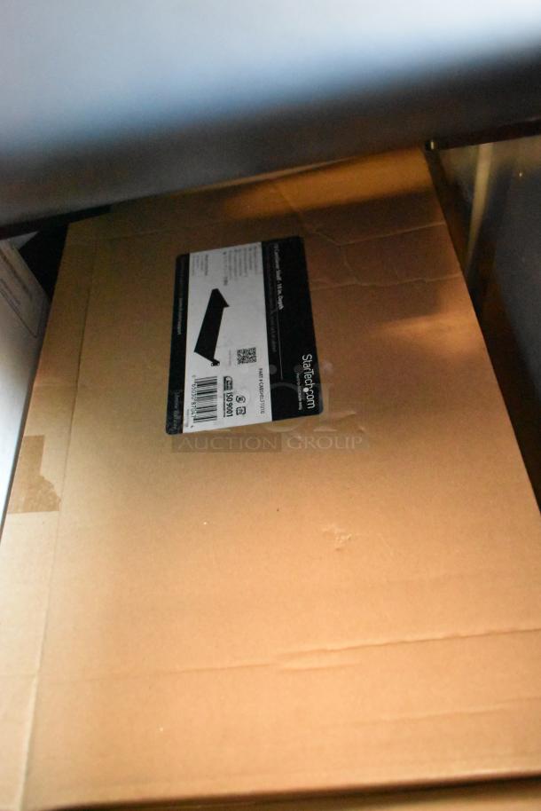 Box labeled StarTech Cantilever Shelf, part of a mixed lot with Avigilon units in a gray bin.