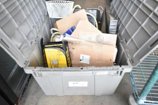 Poly bin with various items including a gas monitor box and Dymo LetraTag. Condition unverified. Marked with auction tag 216.