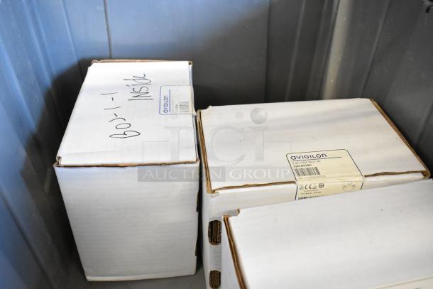 Three brand new Avigilon 2.0C-H5A-D1-IR cameras in unopened boxes with product labels showing model and specs.