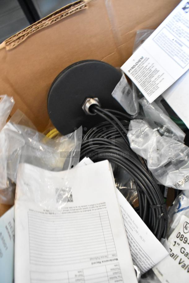 Lot of new items including Tripp Lite unit and Mobile Mark wires in original packaging. Includes various cables and papers.