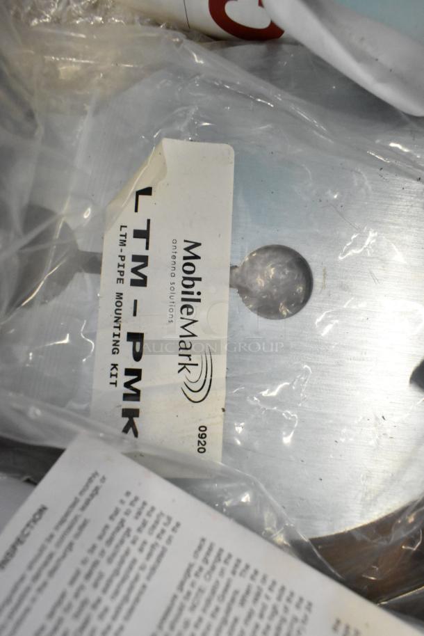 Brand new lot of various items with Mobile Mark LTM-PMK mounting kit label visible, wrapped in plastic.