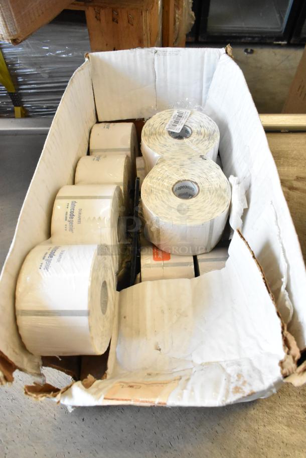 Box containing various rolls of labels, some branded "date code genie." Box shows signs of wear. Suitable for retail use.