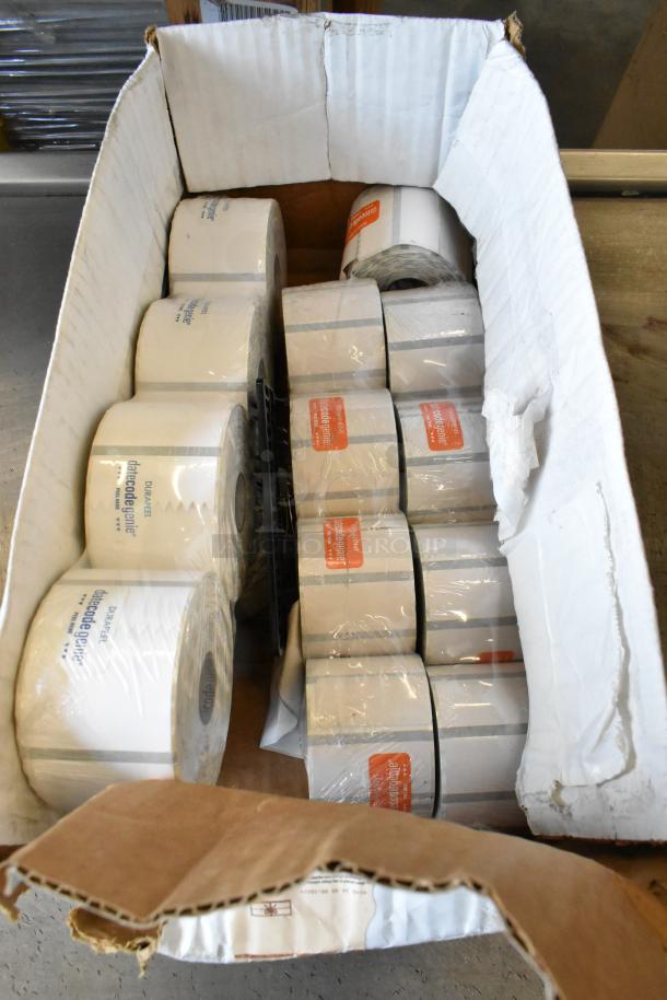 Box of various label rolls, including Data Code Genie brand. White cardboard box, some packaging visible, good condition.
