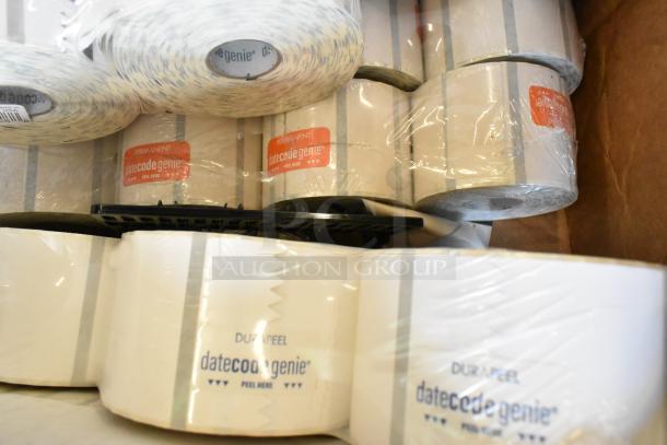 Box of various items including multiple rolls of DateCodeGenie labels, featuring "PERMANENT" and "DUAPPEEL" markings.