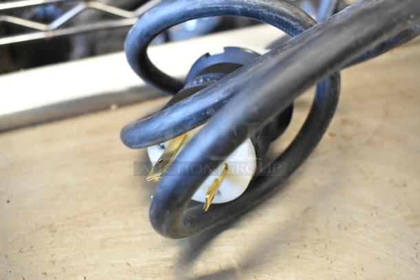Close-up of a power plug for a Prince Castle 464-B stainless steel toaster, showing new condition.