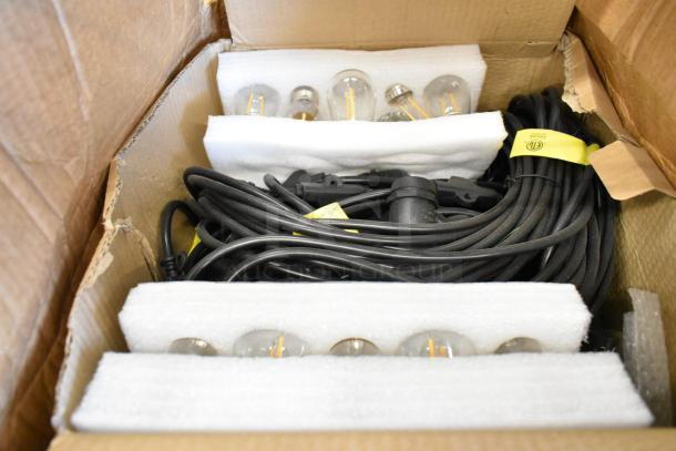 Brand new set of lights in box, includes bulbs and cords, secured with foam padding, yellow safety labels visible.