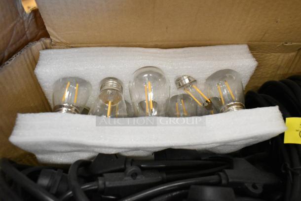 Brand new set of filament light bulbs in a box, packed with foam. Includes protective packaging and visible black cords.