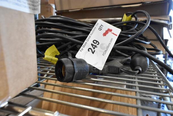 Coiled black wire with connector on metal shelf, tagged "249" by PCI Auctions, indicating item number and auction site.