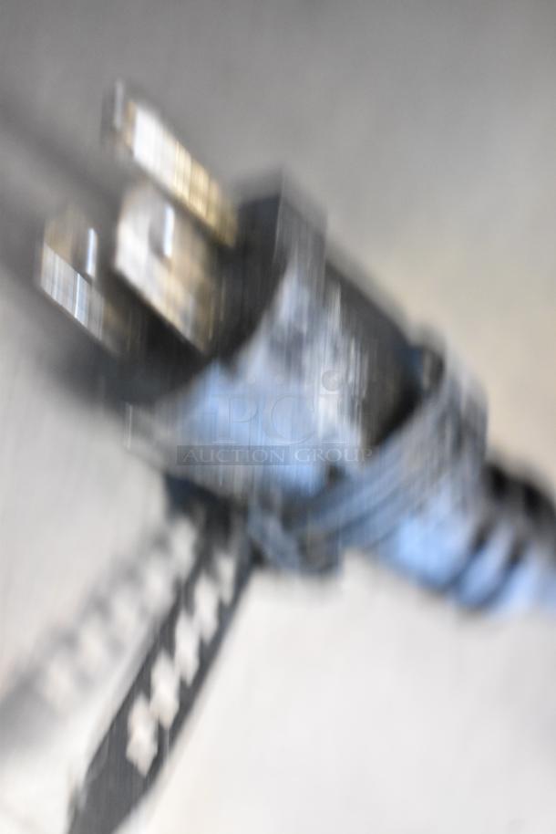 Blurry image of a plug. The item description mentions a Waring WFG257 stainless steel panini press.