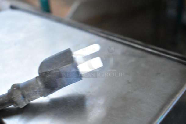 The image shows a close-up of a black plug for a Winco ESG-1 stainless steel commercial countertop panini press.
