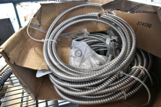 Brand new Reloc OFC 277 12/2G 13 M5 OnePass fixture cable in original box, loops of silver metallic conduit visible.