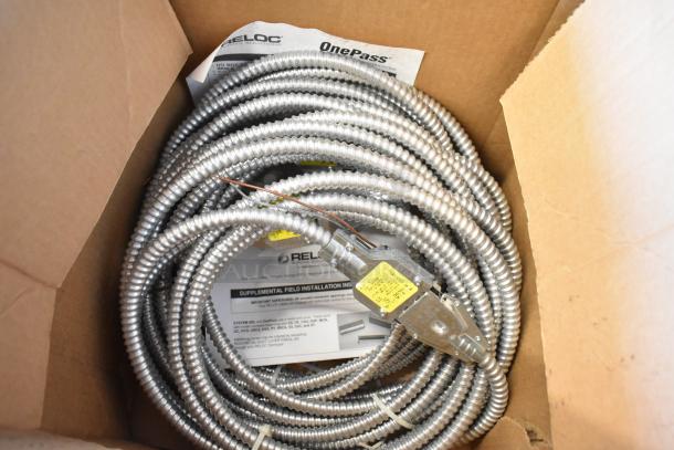 Brand new Reloc Cable in box, coiled metal design, attached labels with installation instructions, indicating unused condition.