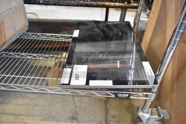 Flat screen monitor on a metal shelf, brand label "elo" in corner, auction tag marked "267." Appears in good condition.