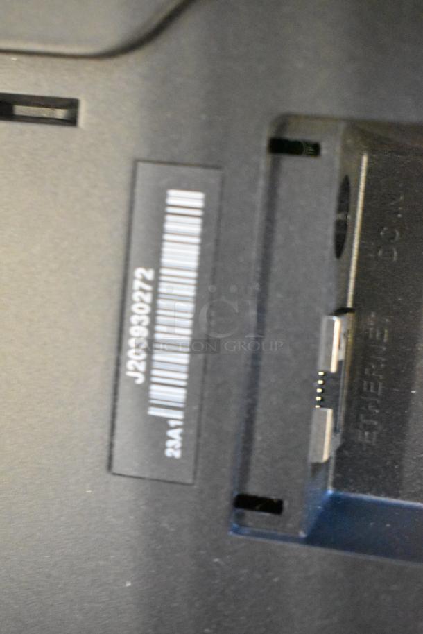 Close-up of monitor back showing barcode with numbers 1203990272 and Ethernet port, indicating connection options.