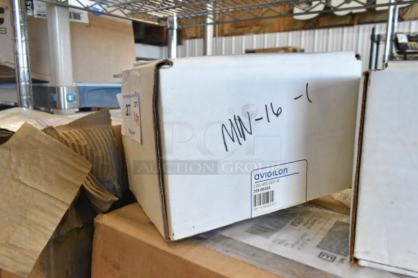 Boxes with Avigilon camera, model 2.0C-H5A-D01-IR, new in box, handwritten and printed labels visible, on a shelf.