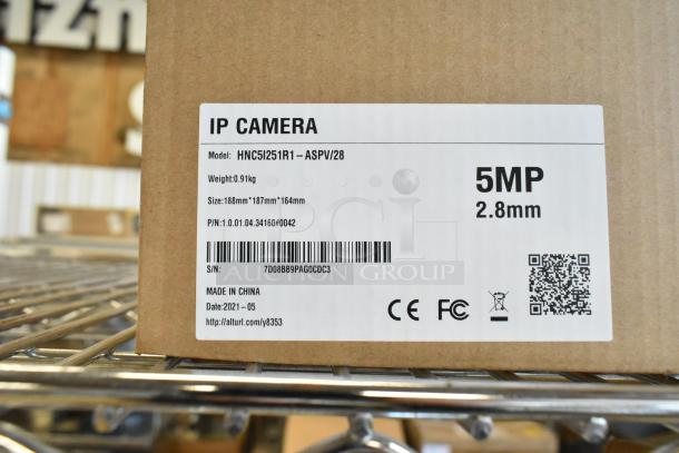 New in box HNC5I251R1-ASPV/28 IP Camera, 5MP, 2.8mm lens, labeled with model, size, weight, and manufacturing info.