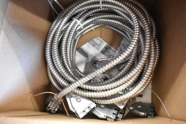 Brand new Reloc Fixture Cable in original box, featuring coiled metal casing and connector ends.