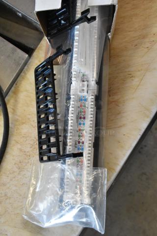 BRAND NEW Tripp Lite N252-024 Cat6 Patch Panel, 24 Port, in original box, with visible mounting brackets and labeling.