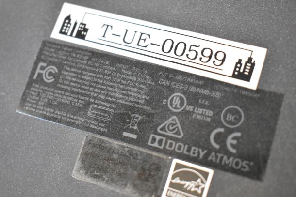 Close-up of a Lenovo tablet back panel featuring FCC, UL, and Dolby Atmos branding. Label shows "T-UE-00599".