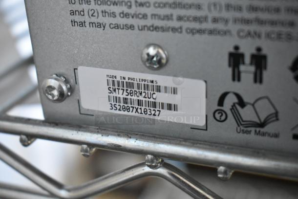 Metal unit with label indicating "Made in Philippines," model SMT750RM2UC, serial 3S2007X10327, includes user manual icon.
