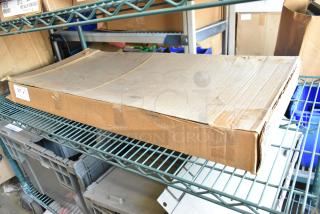 Box of 2 Metro 1836NK3 wire shelves, brand new, unopened package on metal shelf. Visible label says "217 C27".