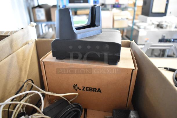 Brand new Zebra docking unit with wires, in box. Logo visible. Ideal for multiple connectivity needs.